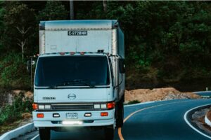 Truck driving down a highway with commercial box truck insurance.